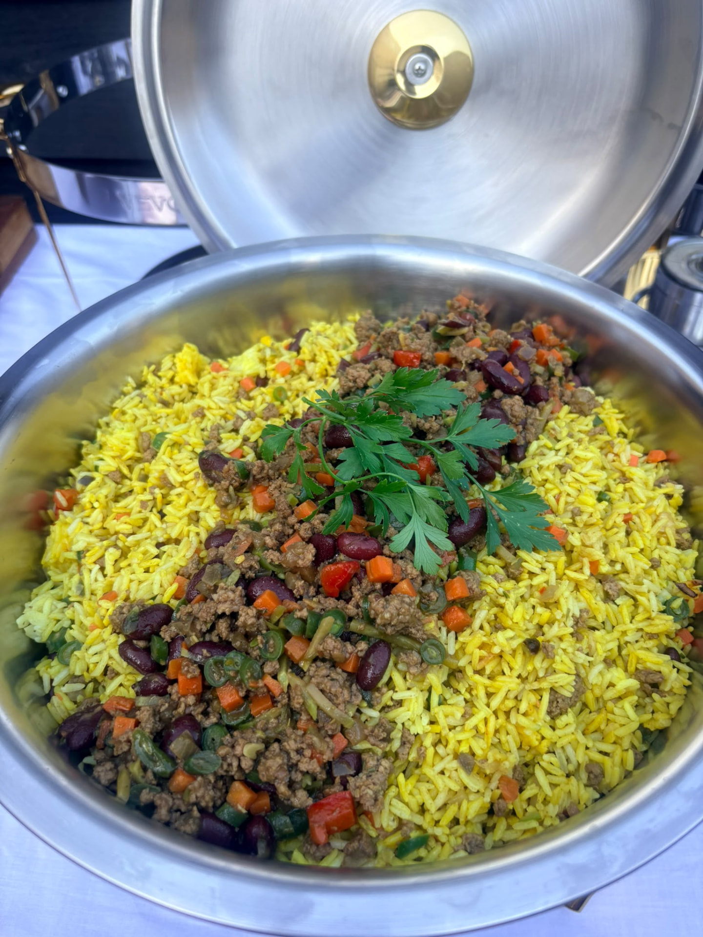 Gele rijst met gehakt en kidneybonen in een chafing dish